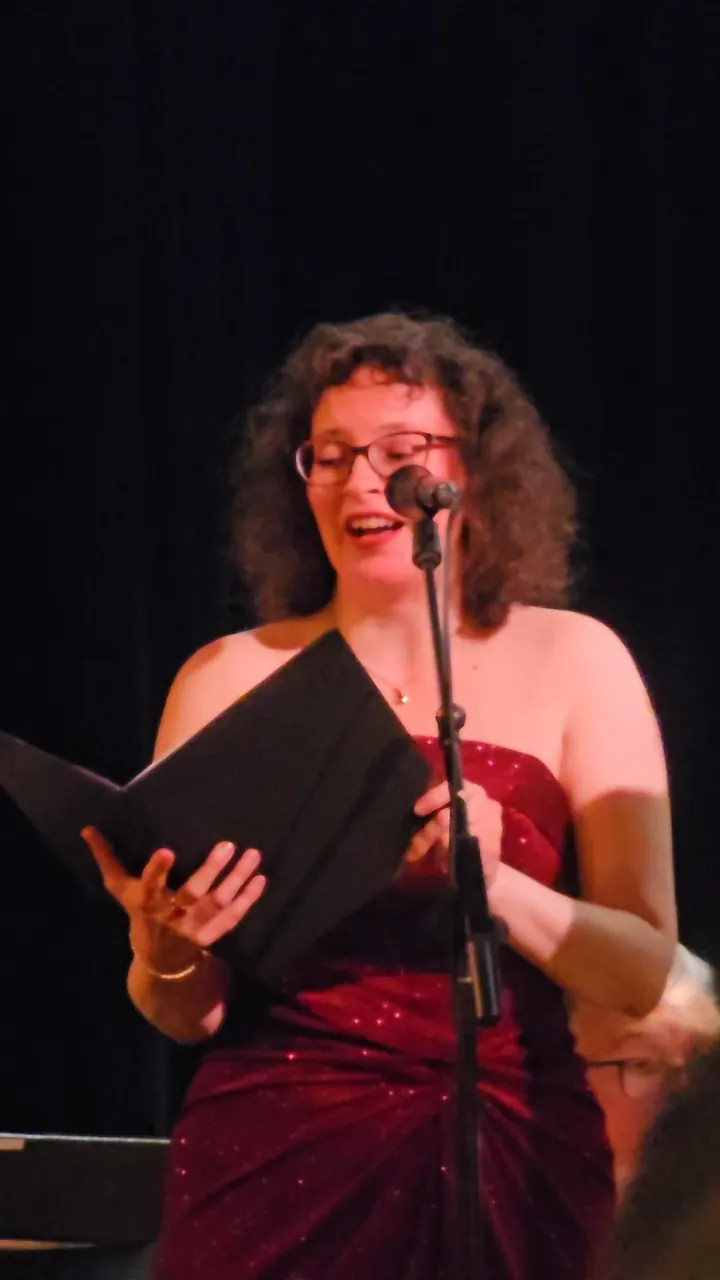 Karin Stein singt mit Notenmappe am Mikrofon